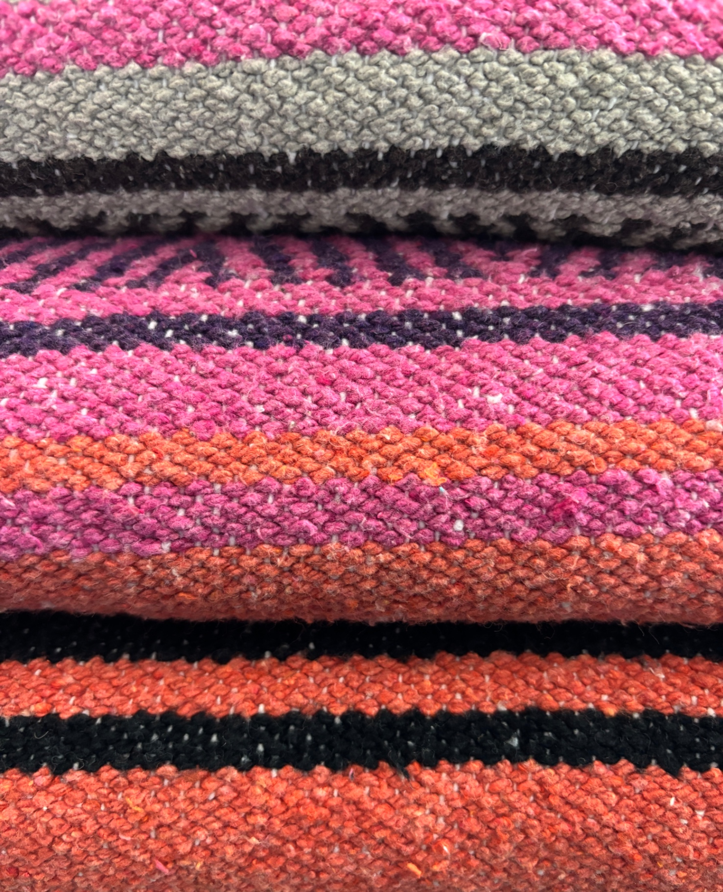 Stacked yoga blankets in warm earth tones